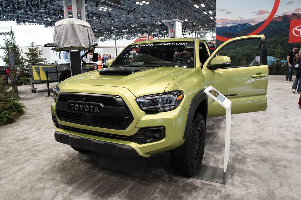 A light yellow green 2022 Toyota Tacoma at a car show