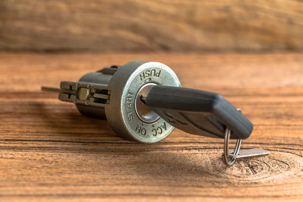 Ignition lock with car keys on wooden background