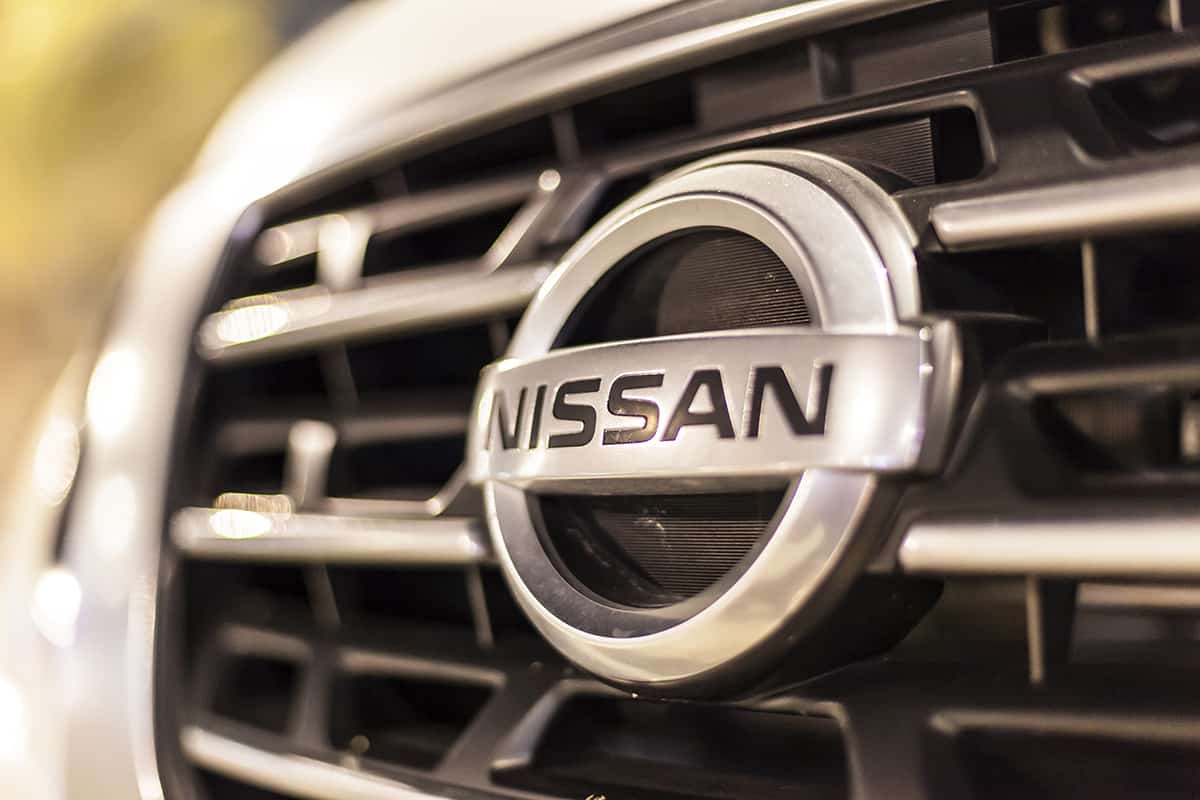 Nissan company logo on a car illuminated at night