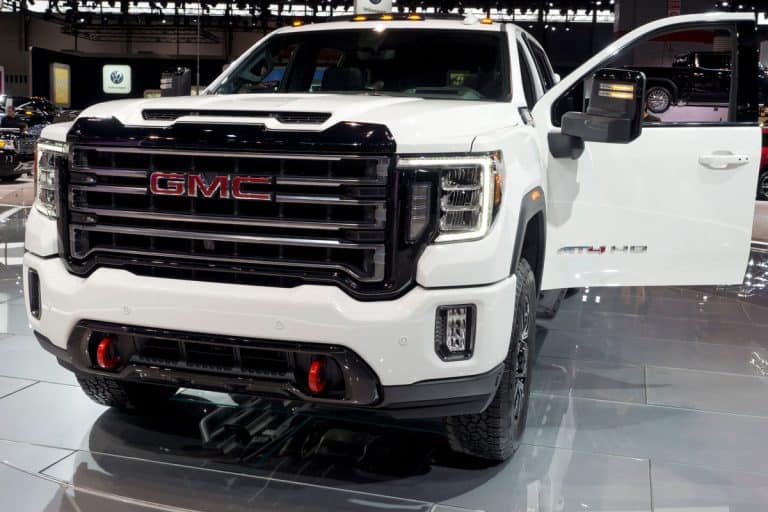 photo of a glossy metallic white GMC sierra on the GMC show room brand new model, How To Turn On Mirror Lights On GMC Sierra