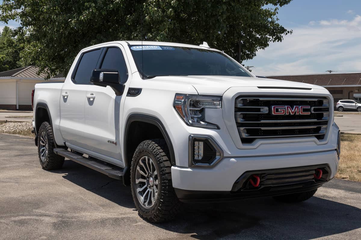 photo of a glossy metallic white paint gmc sierra pick up truck car vehicle on outdoor car park