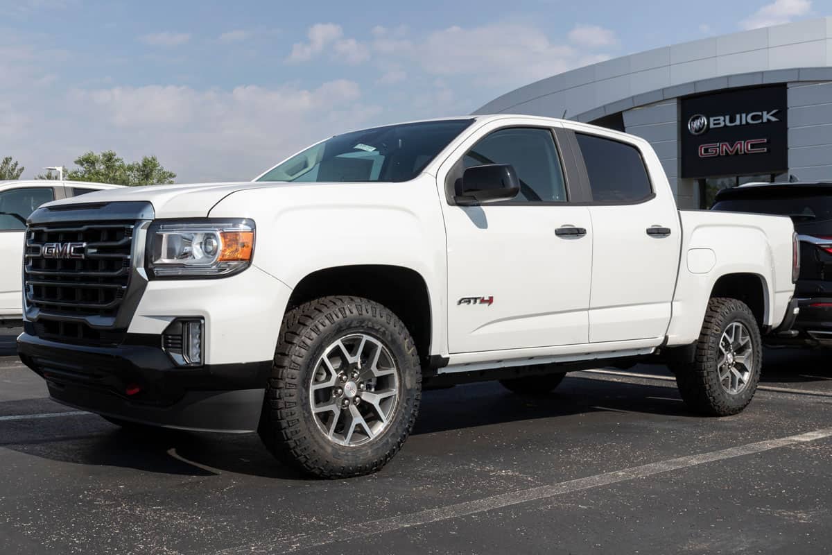 photo of a white painted gmc sierra on a car display center of gmc company parking lot