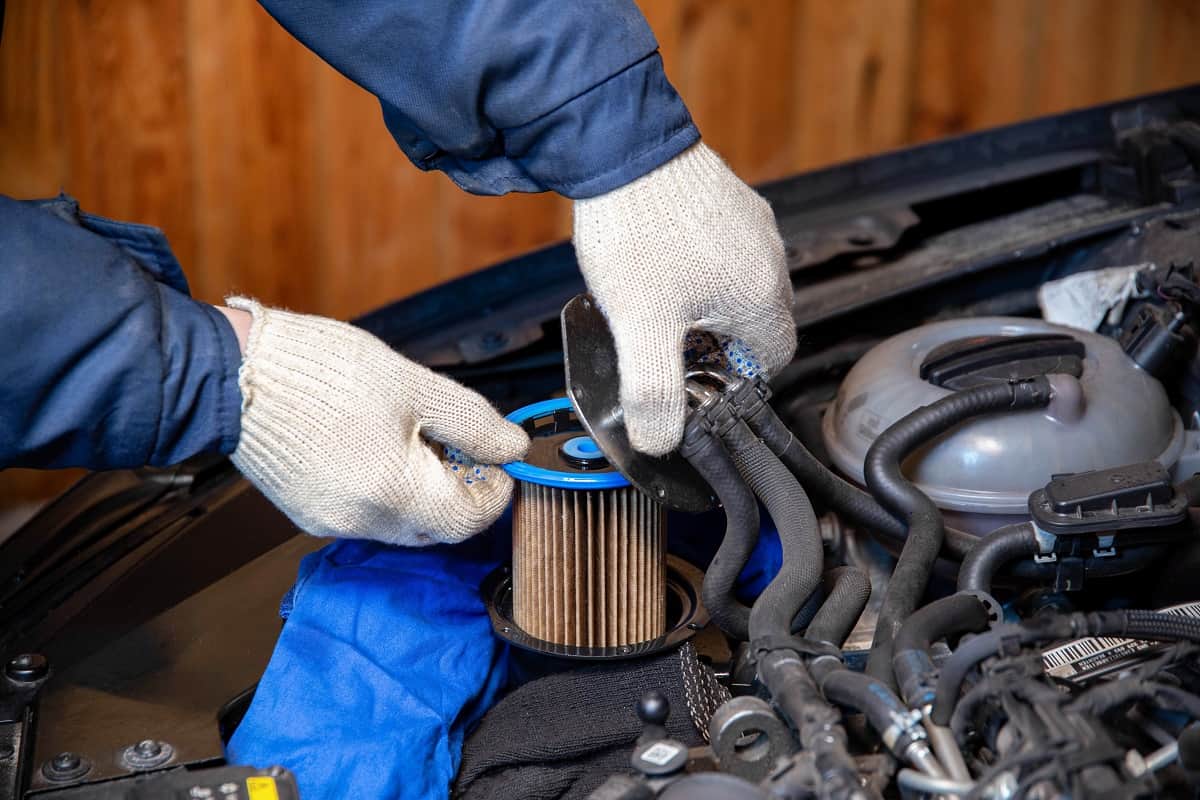 Dirty Fuel Filter - A mechanic takes out an old, dirty fuel filter after refueling with low-quality fuel.