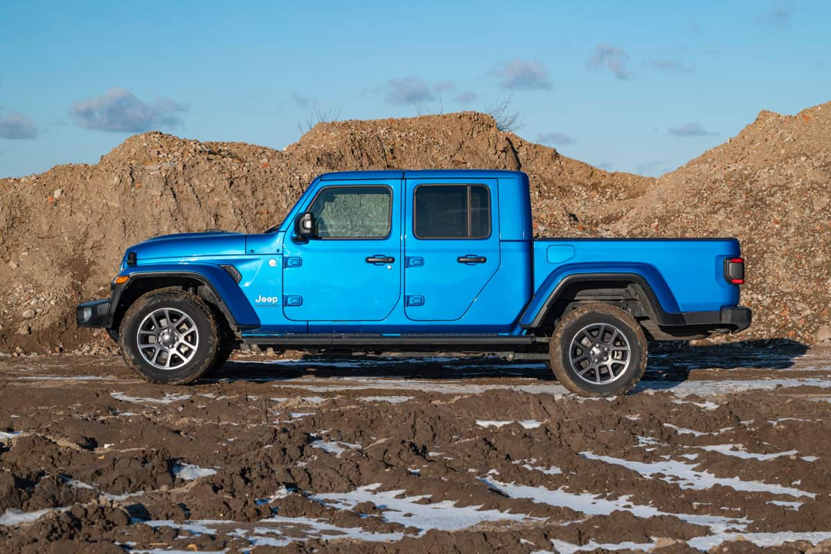 blue Jeep Gladiator on a road on the mountain