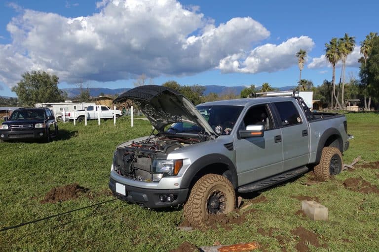 A Ford F150 and a Toyota Sequoia are stuck in deep mud in a field, working on getting pulled out via self rescue, How To Get A Truck Out Of The Mud
