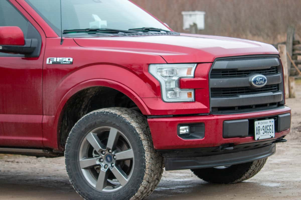  Editorial photograph of a ford F150 with large winter tires that are all muddy from off road driving. 