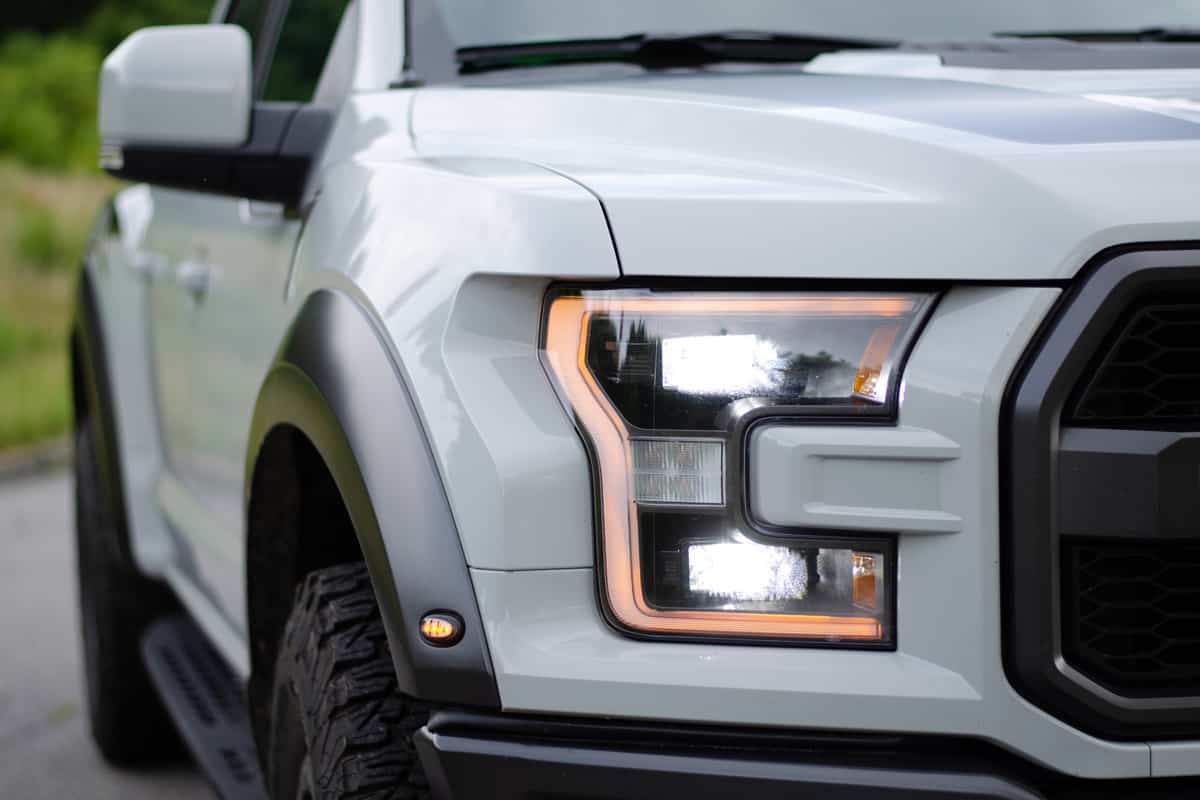 Ford F150 Raptor headlights and grill isolated with grass background