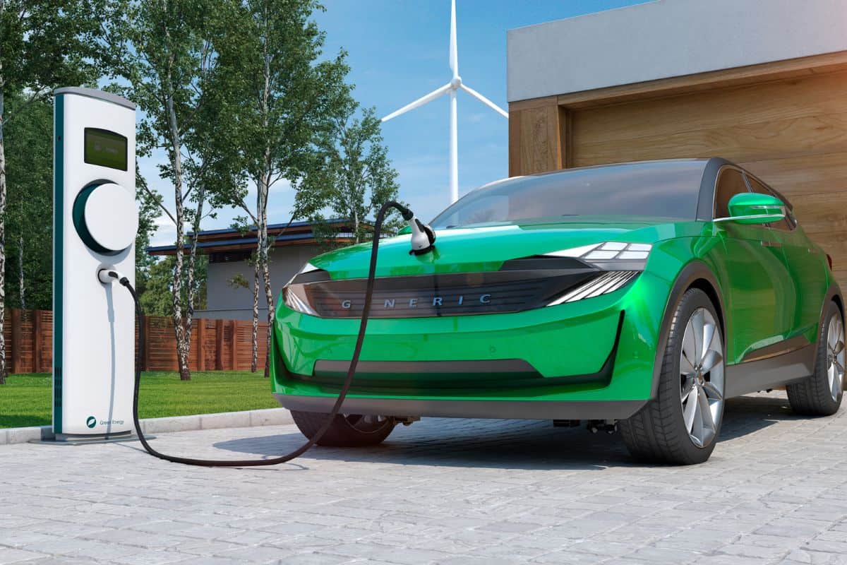 Electric car SUV charging at home in front of modern low energy suburban house

