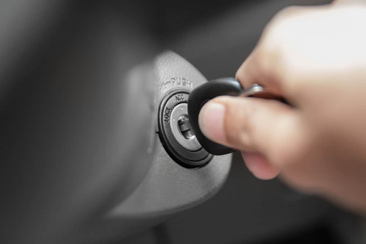 hand's man plug in a key, starting the engine of a car