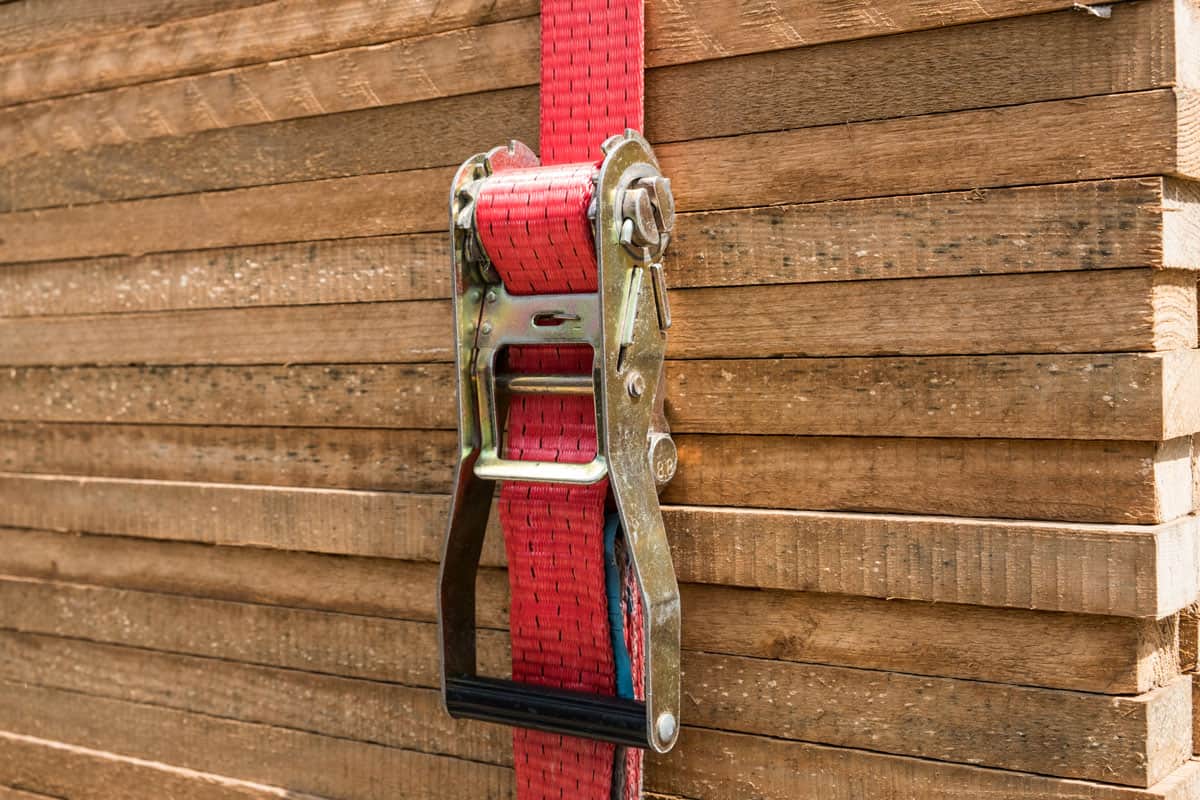 red ratchet strap fixing wood boards cargo
